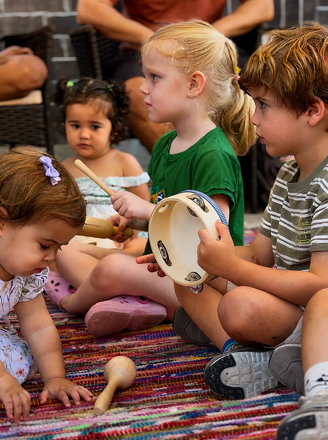Crianças brincando com pandeiro e instrumentos na roda de música